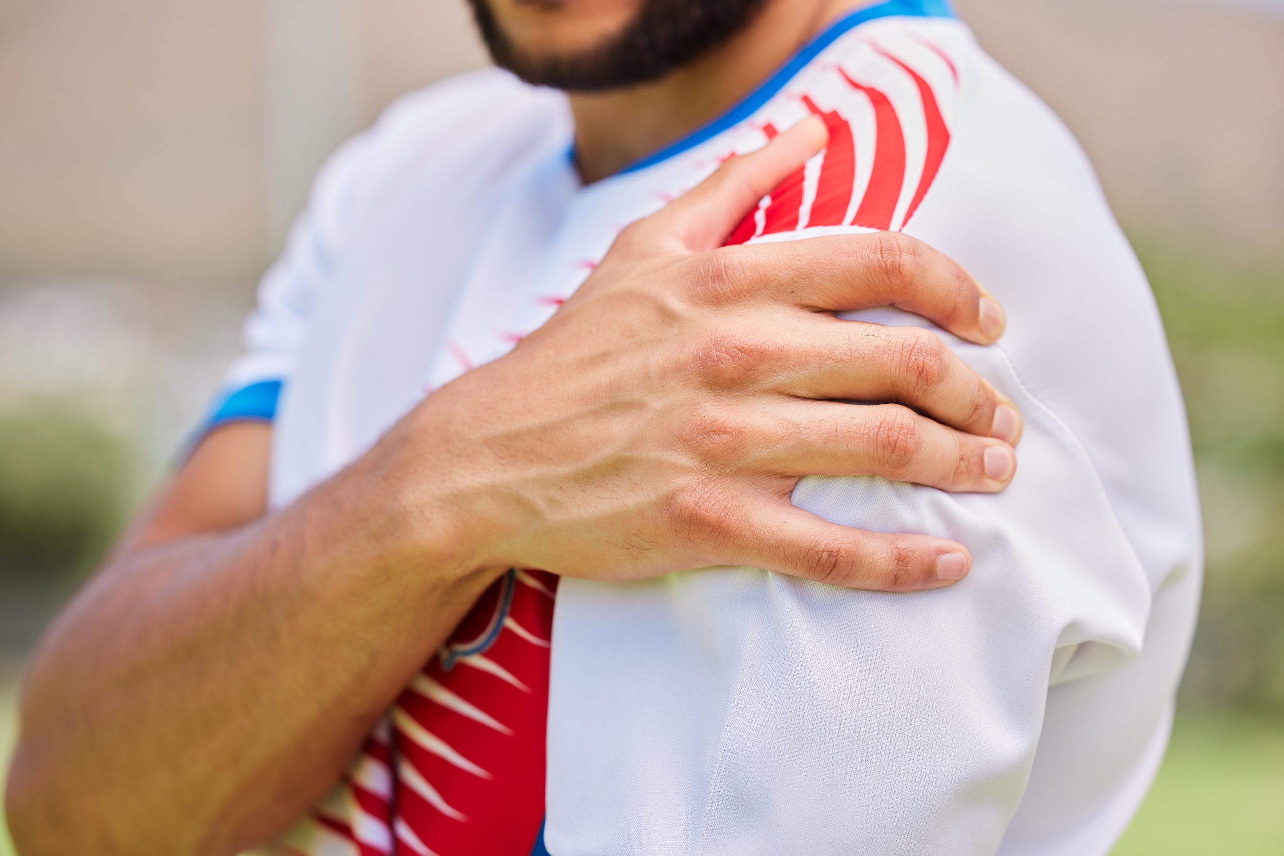 Sports, soccer and hands of man with shoulder pain from training game, soccer field accident or fitness exercise workout. Athlete emergency, injury problem and hurt football player with muscle strain.